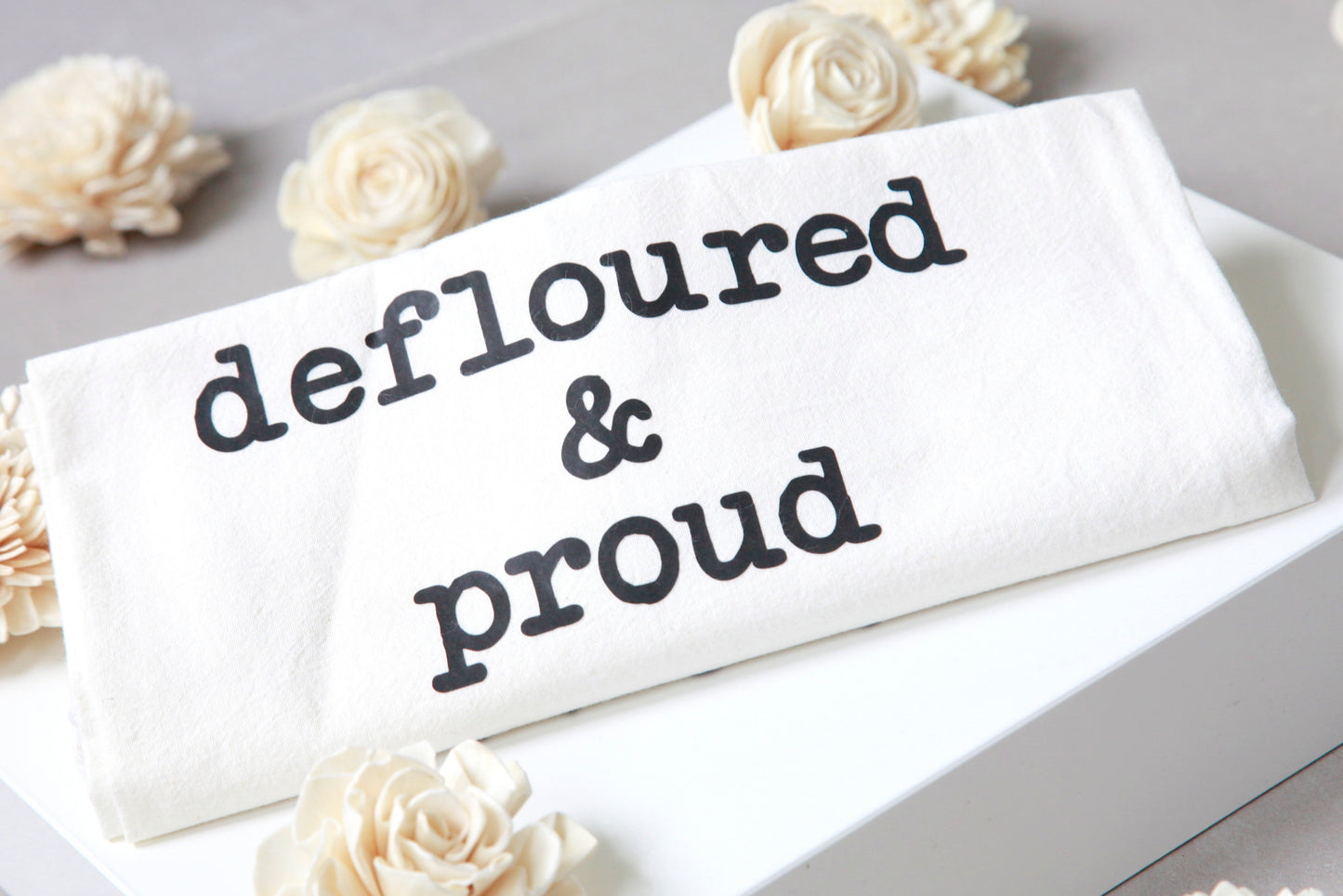 defloured & proud- tea towel